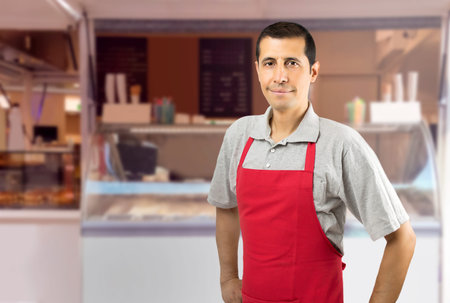 Smiling ice cream car employee with apron at beach