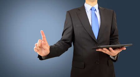 Cropped shot of a corporate businessman connecting to a user interface with his fingerの写真素材