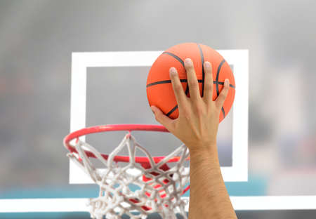 Cropped of hand of a male basketball player in action against at stadiumの写真素材