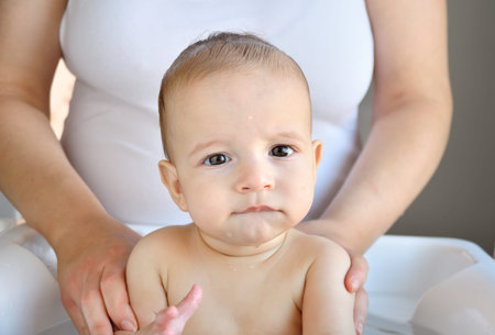 Cropped shot of a baby boy being bathed by her mother
