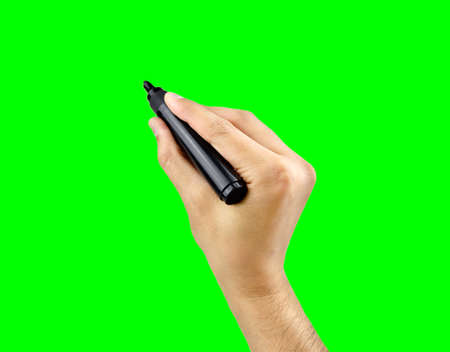 Male hand is ready for drawing with black marker isolated cutout on green background with chroma keyの写真素材