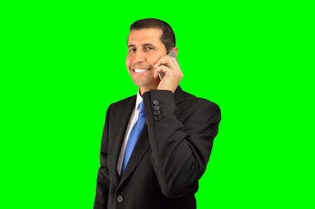 Cropped shot of a businessman talking by cellphone and standing isolated cutout on green background with chroma keyの写真素材