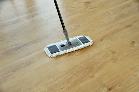 cleaning gear mopping a living room floor with parquetの写真素材
