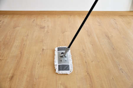 cleaning gear mopping a living room floor with parquetの写真素材