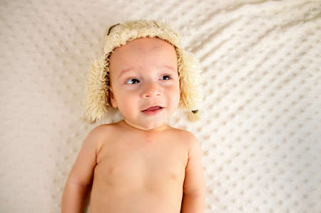 Baby in hat and looking upの写真素材
