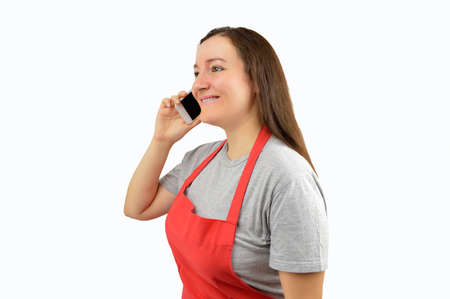 shopwoman with apron uses a smart phone with white backgroundの写真素材