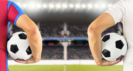 Cropped rear view image of two young players men holding a soccer ball under his arms at stadium with copy spaceの写真素材