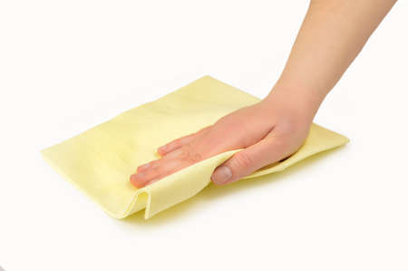 Hand wiping surface with yellow rag isolated on whiteの写真素材