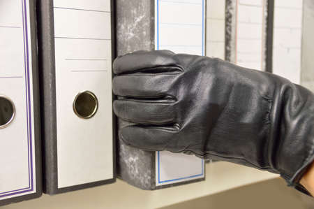 thief stealing ring binder and confidential files in an officeの写真素材