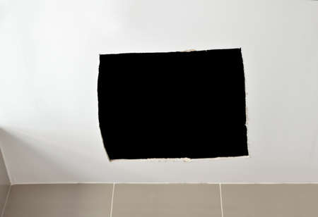 Ceiling panels damaged as a huge hole in the roof from rainwater leakage.の写真素材
