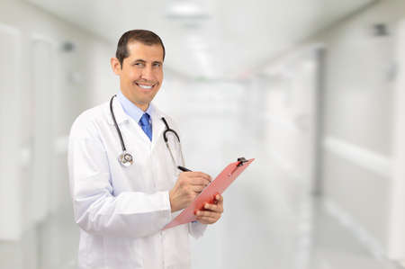 happy male doctor with clipboard and stethoscope over clinic backgroundの写真素材