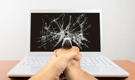 Man shoots with gun at his laptopの写真素材