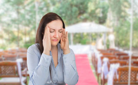 wedding planner woman is organizing  the wedding reception venue for her customers standing and stressed for lack of time at the wedding placeの写真素材