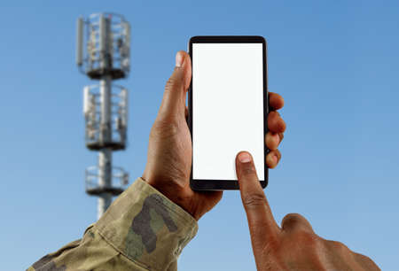 hands of a soldier looking for signal for the phoneの写真素材