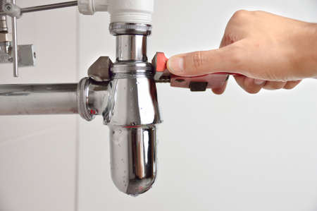 plumber fixing sink pipe with adjustable wrenchの写真素材