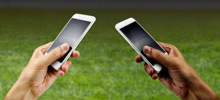 friends using the phone to bet on the stadiumの写真素材