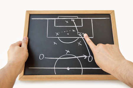 coach indicating with the finger the tactic of the meeting on the blackboard with white backgroundの写真素材