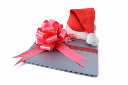 Close-up of laptop computer christmas gift with a ribbon isolated on a white backgroundの写真素材