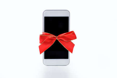 Close-up of phone gift with a red ribbonの写真素材