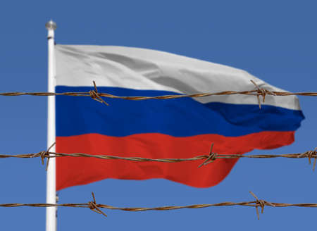 Metal fence with barbed wire on a russian flag. Separation concept, borders protection.Social issues on refugees or illegal immigrantsの写真素材