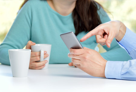 Two friends watching media in a smart phone