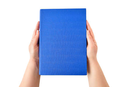 Female hands holding closed book with blue cover on light backgroundの写真素材