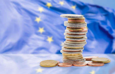 Coins stacked on each other in different positions with european union flagの写真素材