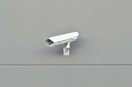 security camera working on the wall of a buildingの写真素材