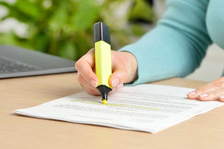 Close up of woman hand underlining a document at homeの写真素材