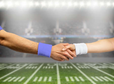 Closeup shot of two rugby players from opposite teams shaking handsの写真素材