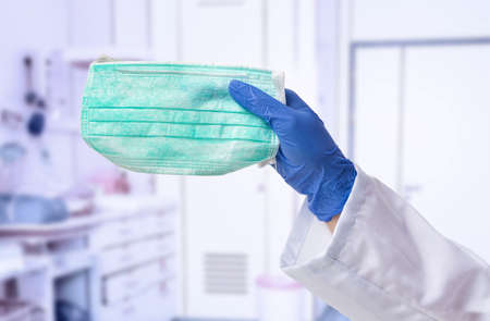Male doctor hand holding a green mask at hospitalの写真素材