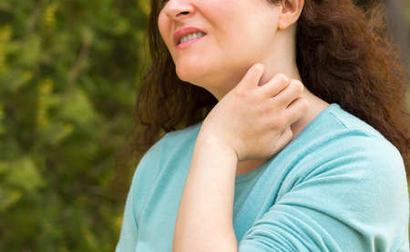 Close-up of woman suffering itching scratching neckの写真素材