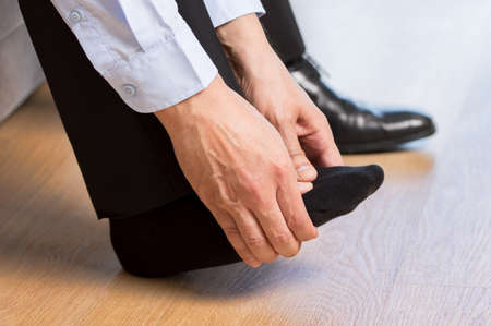 Cropped shot of an unrecognizable man suffering with foot pain in the roomの写真素材