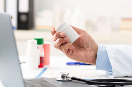Shot of a young doctor filling out a form for a prescription in her consulting roomの写真素材
