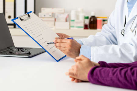 Shot of a confident male doctor showing test results to a patient inside of a hospital during the dayの写真素材