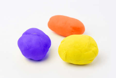 Blue, red and yellow moulds of plasticine in a white surfaceの写真素材