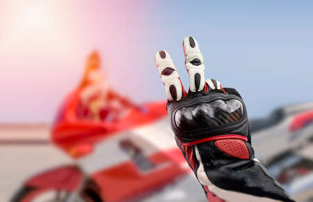 Gesture of biker greeting on the road. typical sign for greeting to another bikers in the wayの写真素材