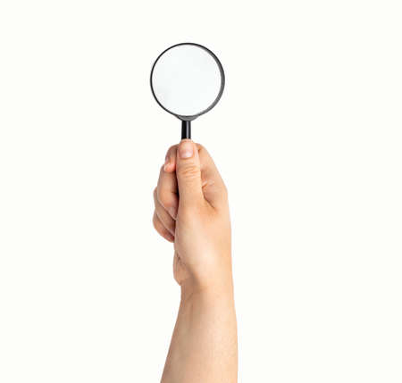Magnifying glass in hand isolated on whiteの写真素材
