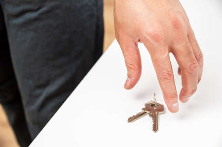 Unrecognizable person holding up a keys at homeの写真素材