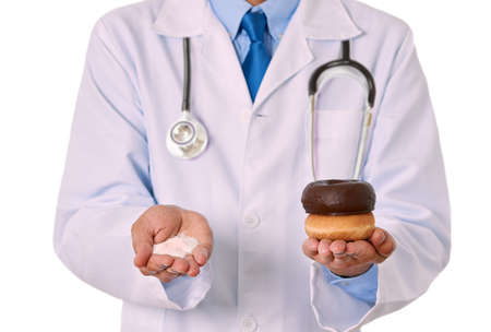 Closeup of a male doctor hand holding sugar and donuts  with white backgroundの写真素材