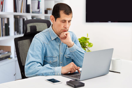 Cropped shot of a handsome young businessman sitting in his home office and looking contemplative...