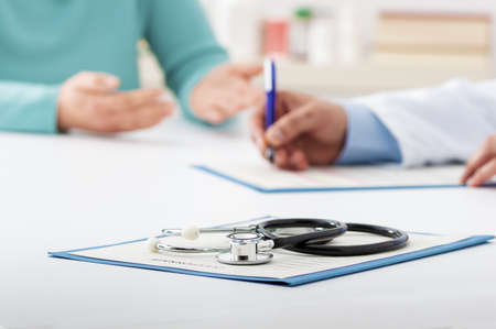 Cropped shot of a female patient talking to a male doctor in his officeの写真素材
