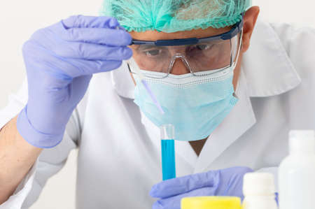 Cropped shot of a young scientist using a pipette to fill test tubes in his laboratoryの写真素材