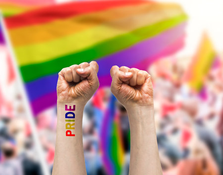 Gay guy's hand with a tattoo that says pride with white background. Symbol of sexual liberation and toleranceの写真素材