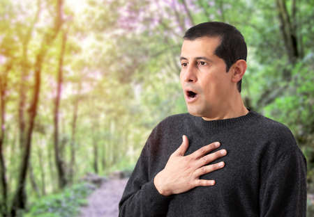 Man suffering respiratory problems at natureの写真素材