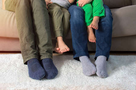 Cropped shot of a family of three relaxing together on the sofa at homeの写真素材