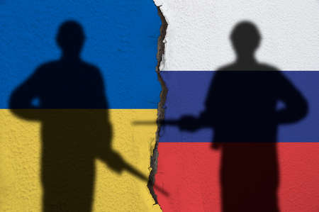 Flag of Ukraine and Russia painted on a concrete wall with soldiers shadows. Relationship
between Ukraine and Russia and conflictの写真素材
