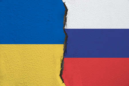 Close-up Ukraine and Russia painted flags on a wall with a crack.Concept of Russia and Ukraine relations.の写真素材