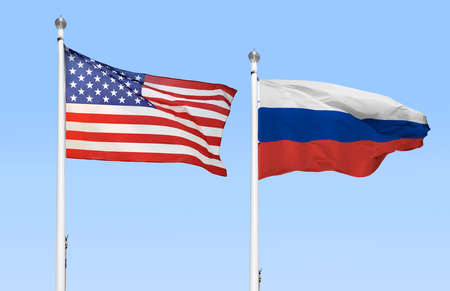 The American and Russian flags flying side by side with blue skyの写真素材