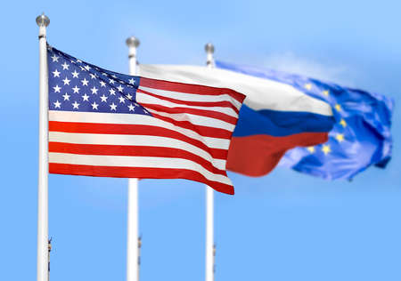 The American ,European Union and Russian flags flying side by side with blue skyの写真素材